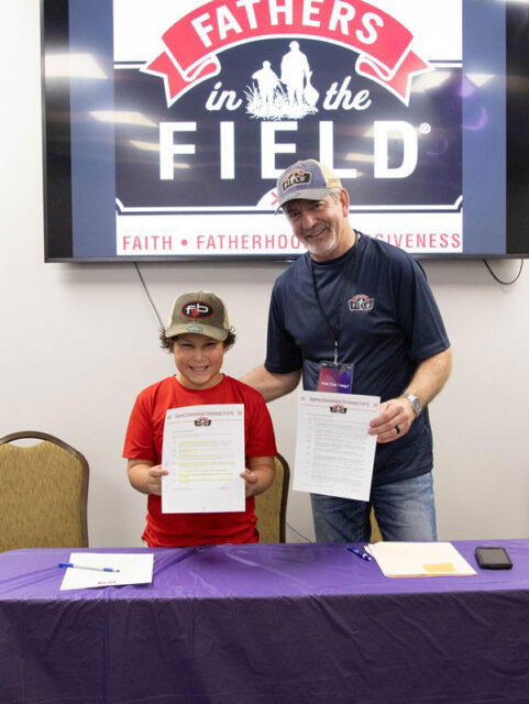 Photo of Mentor Father George and Field Buddy Kamdyn Signing